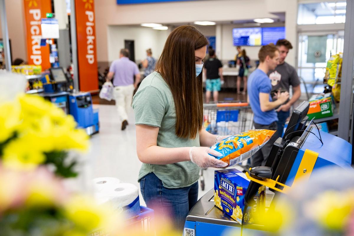 People using self-checkout kiosks