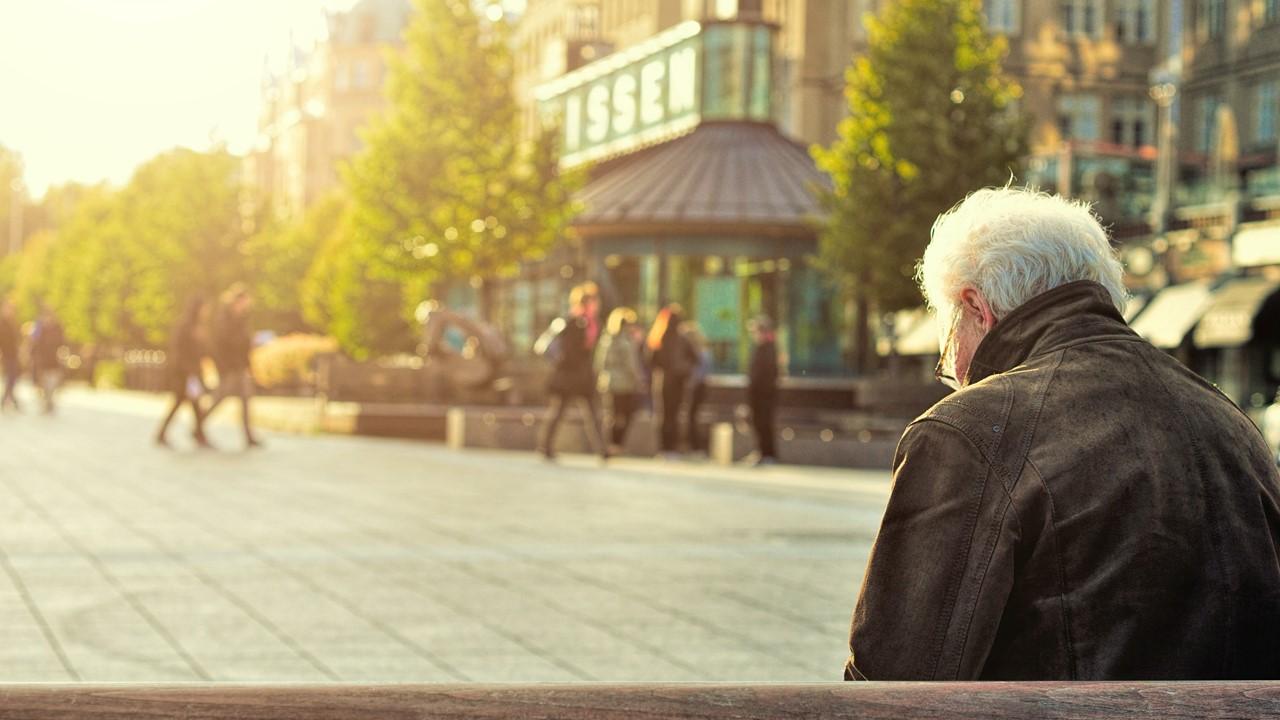 An older man sitting on a bench