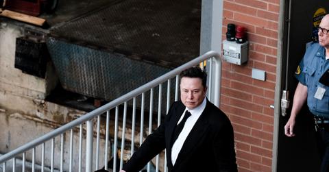 Elon Musk in suit walking