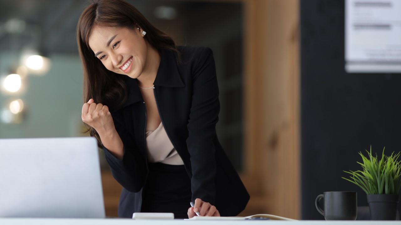 A woman in a black suit looking a Microsoft Rewards on her laptop