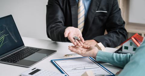 Real estate agents deliver home key to client