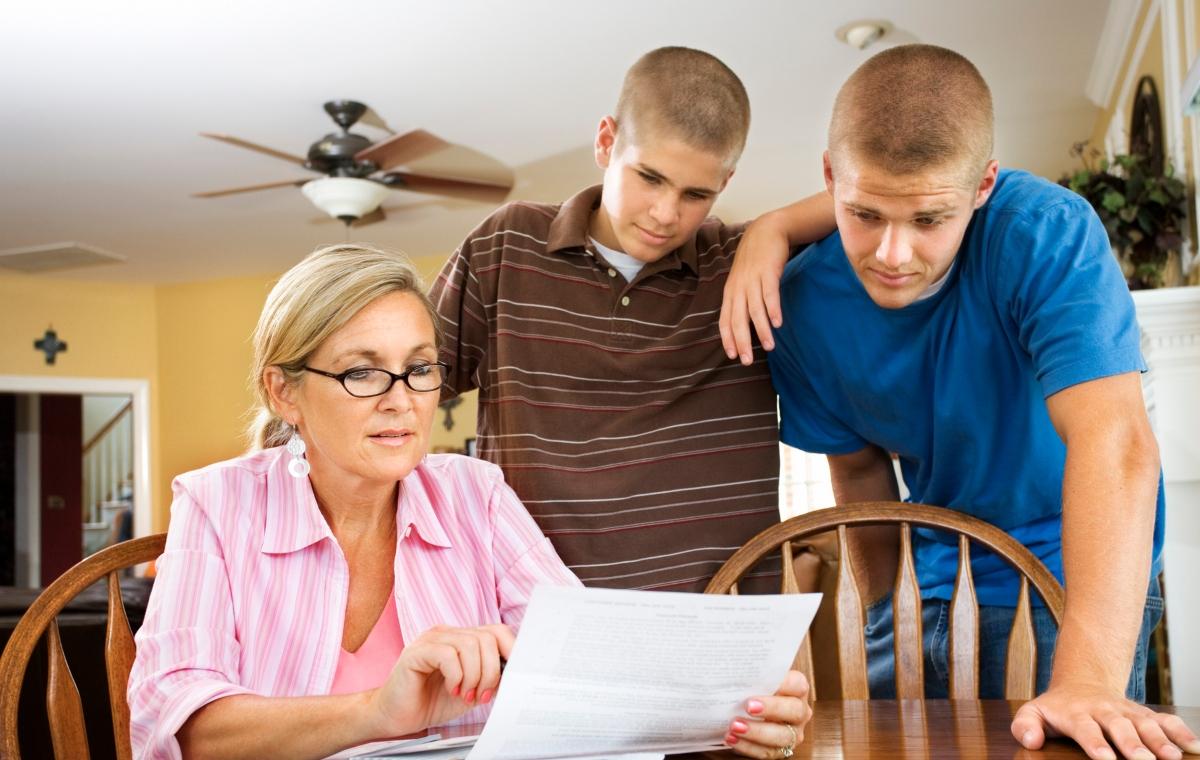 A mother and her sons looking a child support paperwork