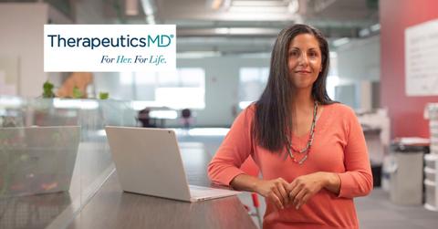 Woman standing near a laptop and TherapeuticsMD logo