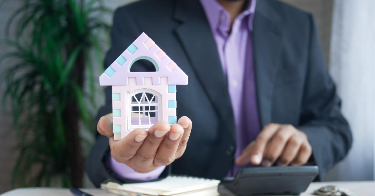 A person holding a miniature house