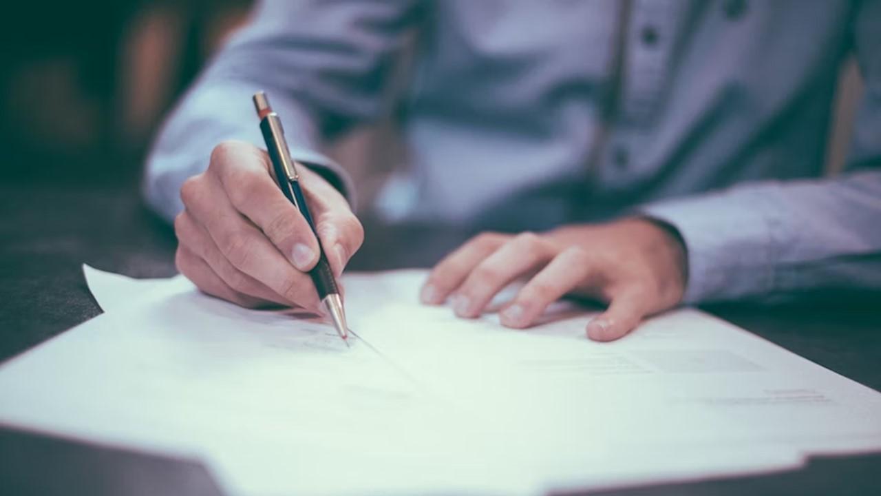 A man signing loan paperwork