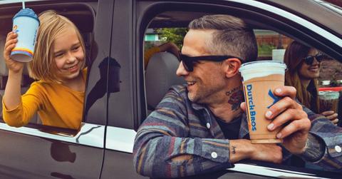 People in a car holding Dutch Bros cups