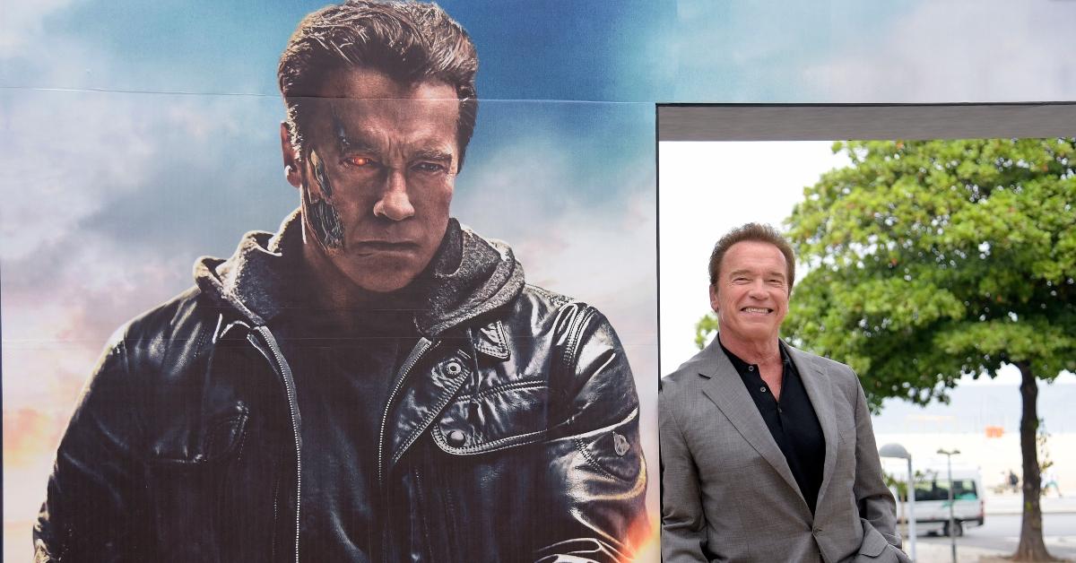 Arnold Schwarzenegger next to a mural of himself