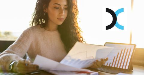 Woman looking at documents and Exela logo