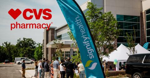 CVS Pharmacy logo over Signify Health sign and building