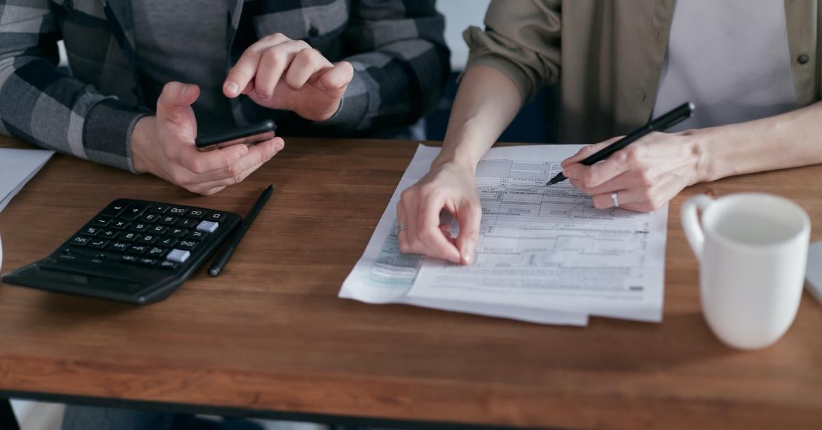 A couple filling out their tax forms and calculating funeral expense deductions.