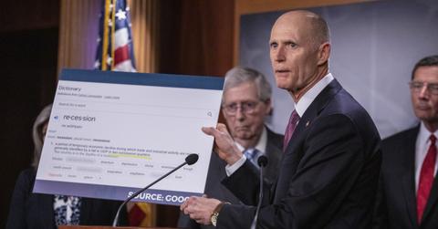 Senator Rick Scott holding up a sign