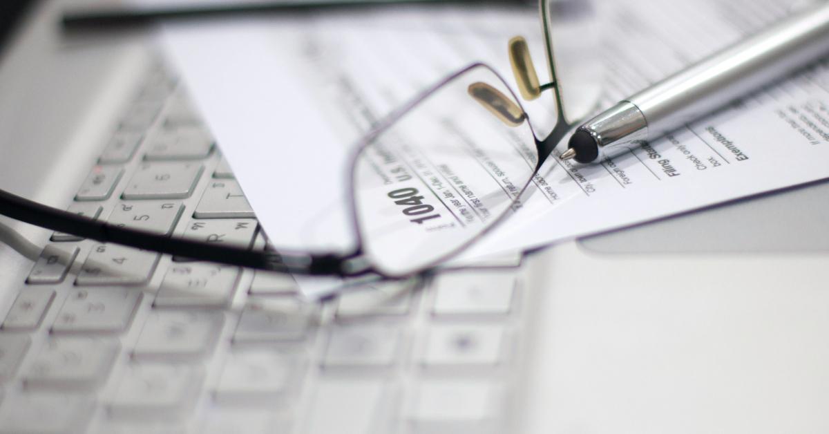 Tax forms sitting under glasses.