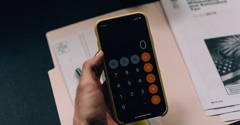 A woman using a calculator to determine her tax refund