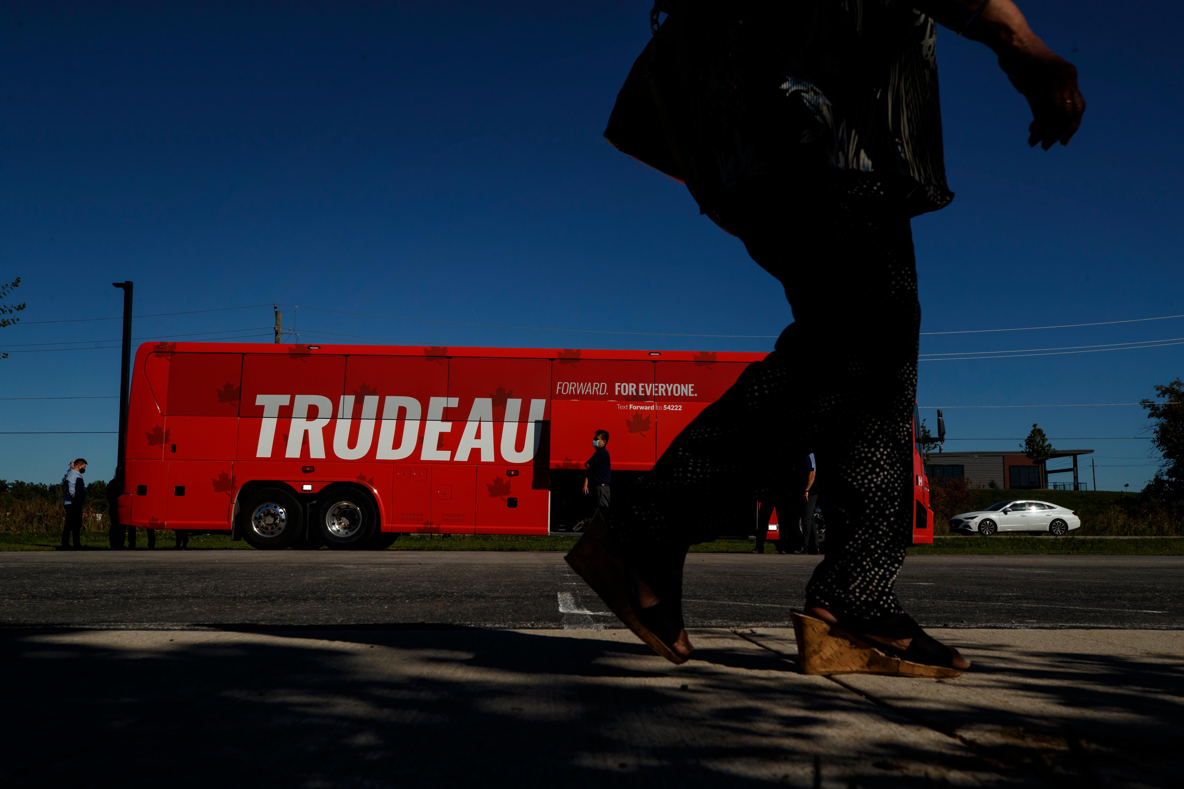 Person walking in front of Justin Trudeau campaign bus