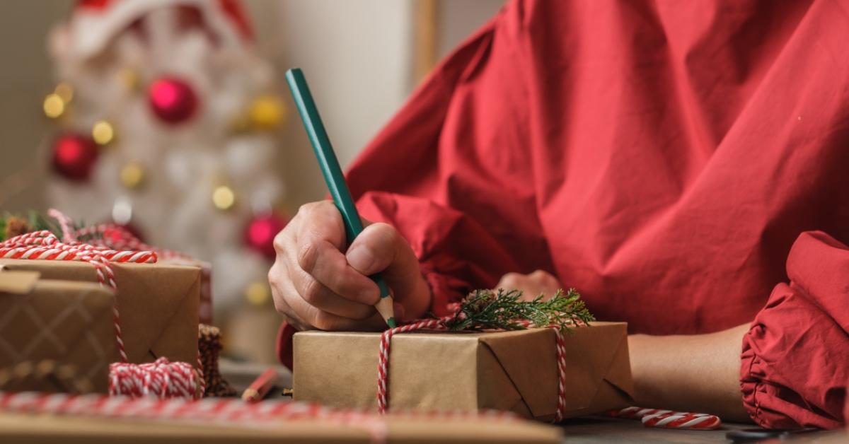 A woman decorating a Christmas present