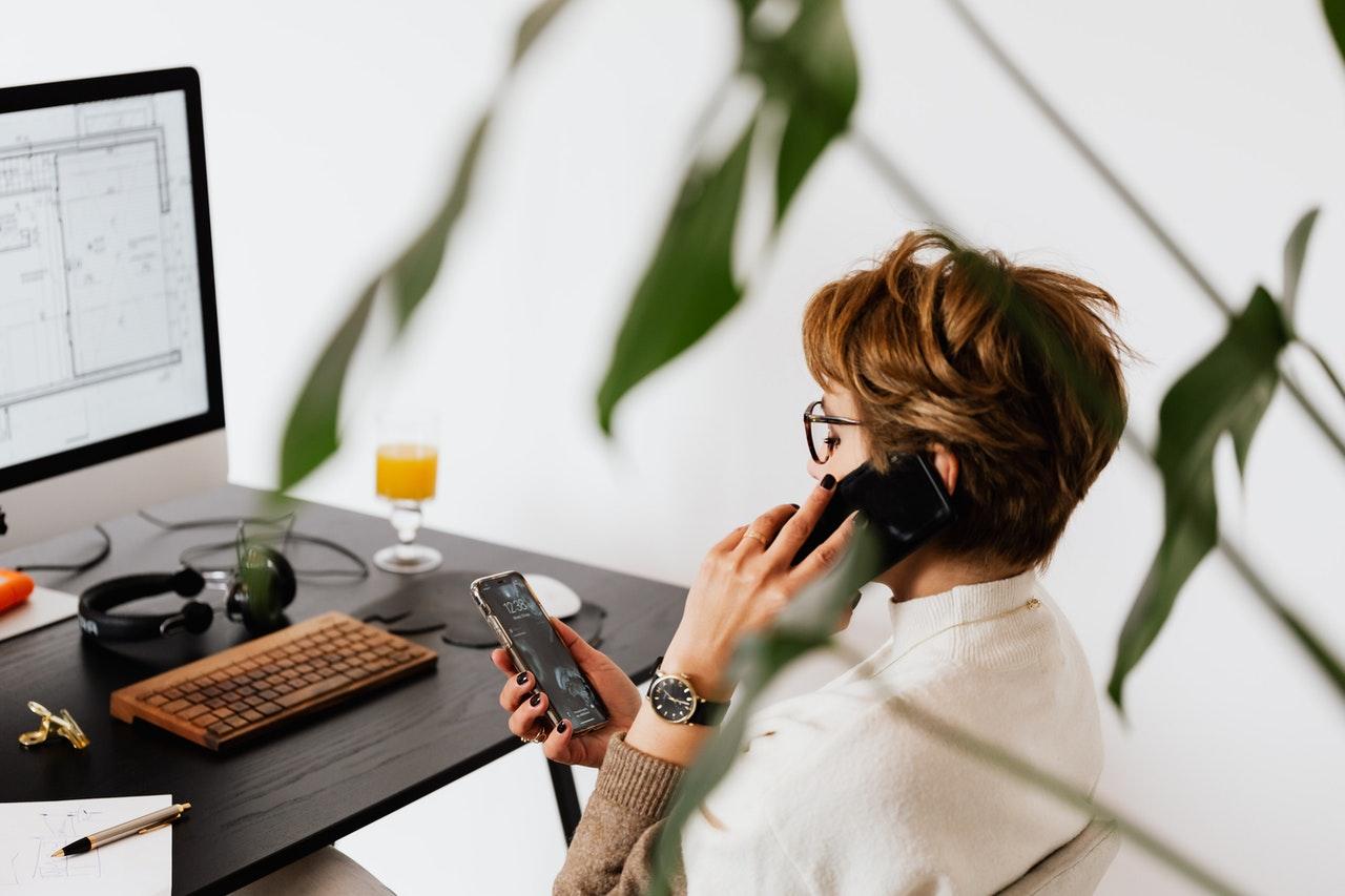 A person working at a desk and talking on the phone