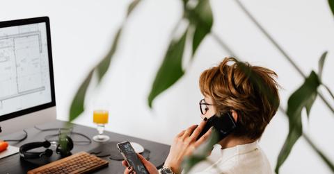 A person working at a desk and talking on the phone