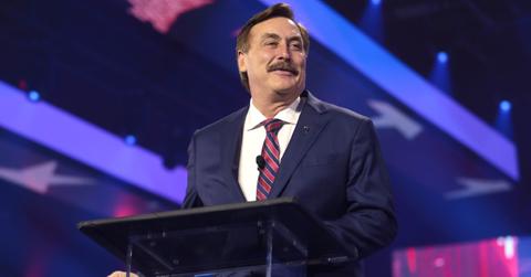 Mike Lindell in a blue suit speaking with attendees at the 2022 AmericaFest.