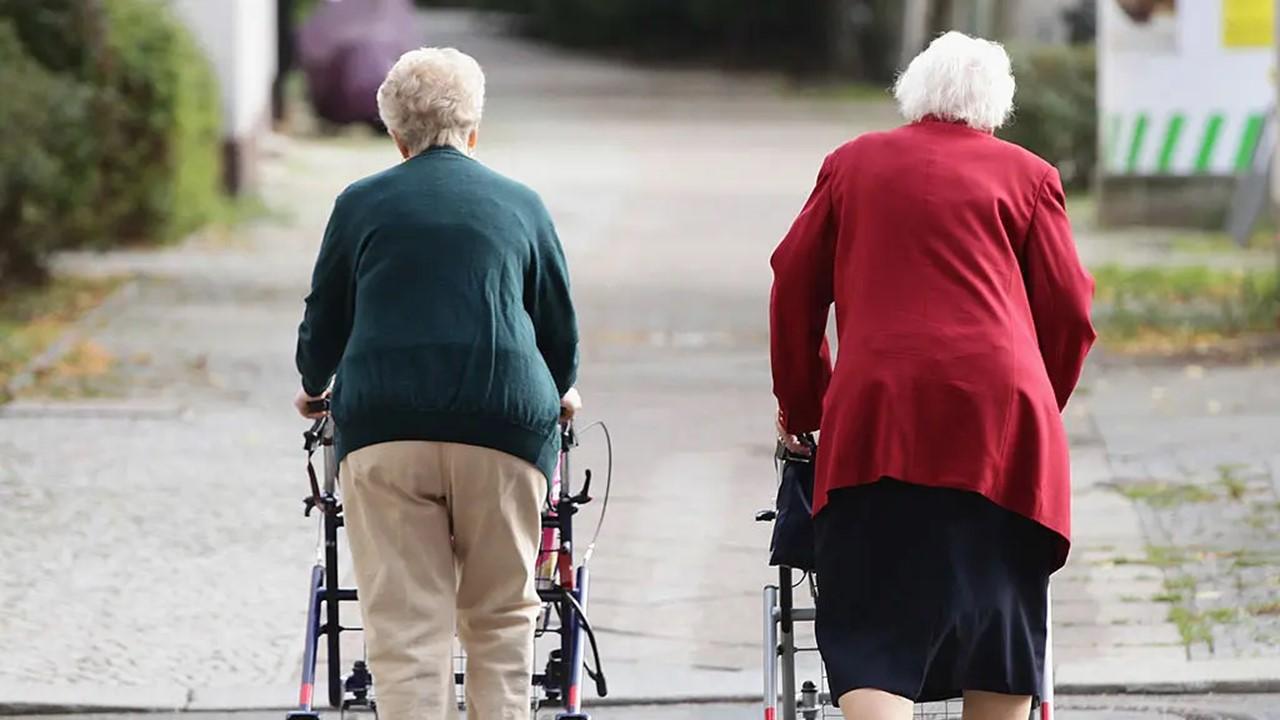 Two elderly ladies walking down a street.