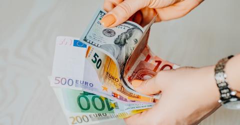 Person holding dollar and euro notes