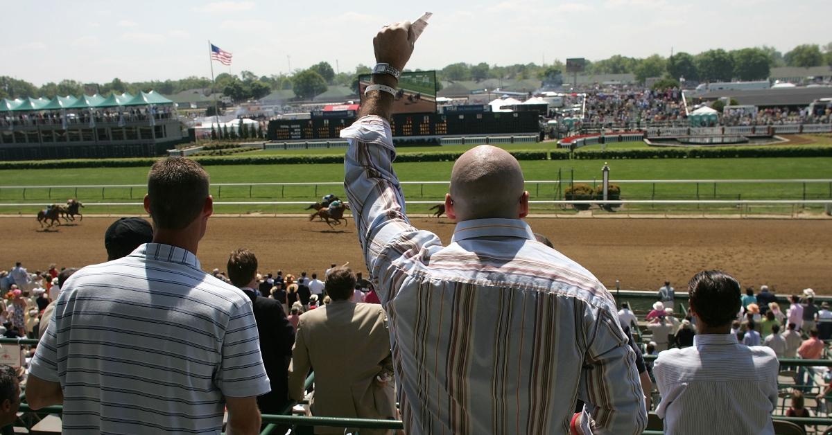 Two men watching a horse race.