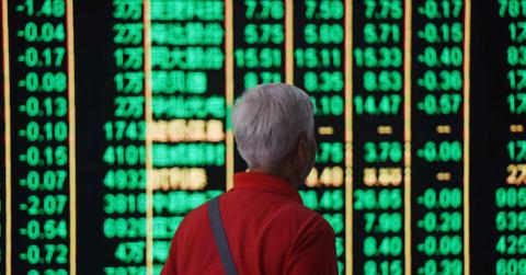 A person looking at Chinese stock market statistics on a board