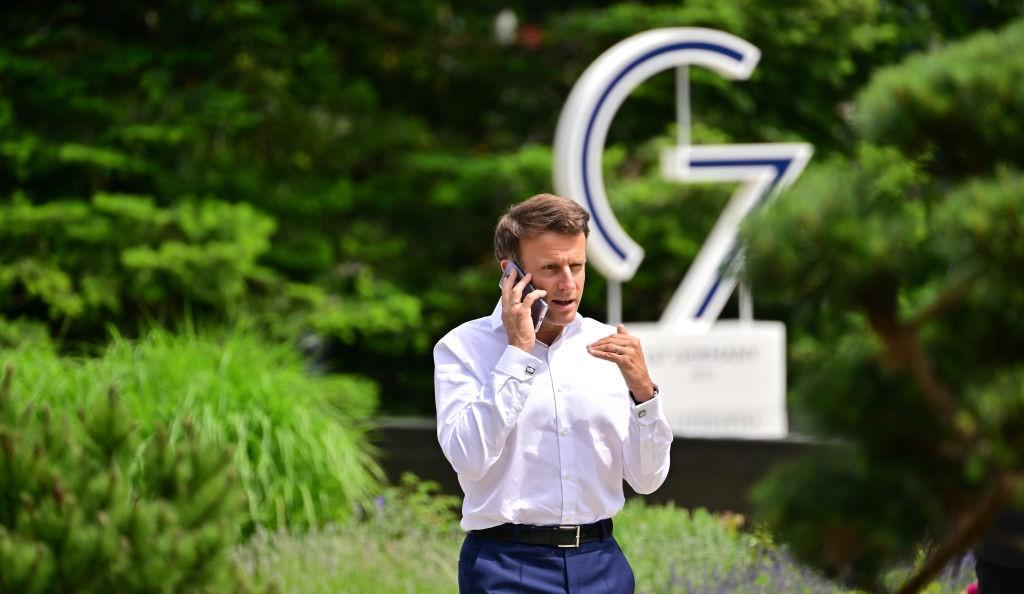 French President Emmanuel Macron in front of a G7 sign