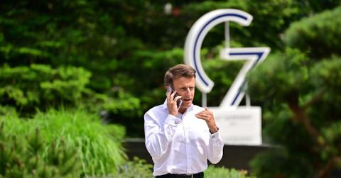 French President Emmanuel Macron in front of a G7 sign