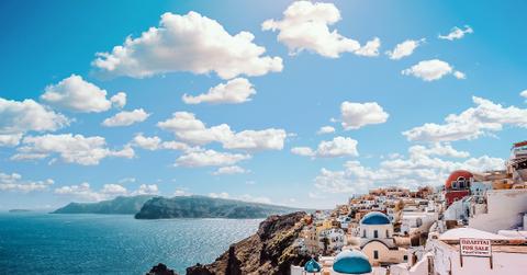 White concrete house near body of Water Under White and Blue Cloudy Sky