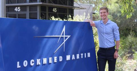 Man standing next to a Lockheed Martin sign