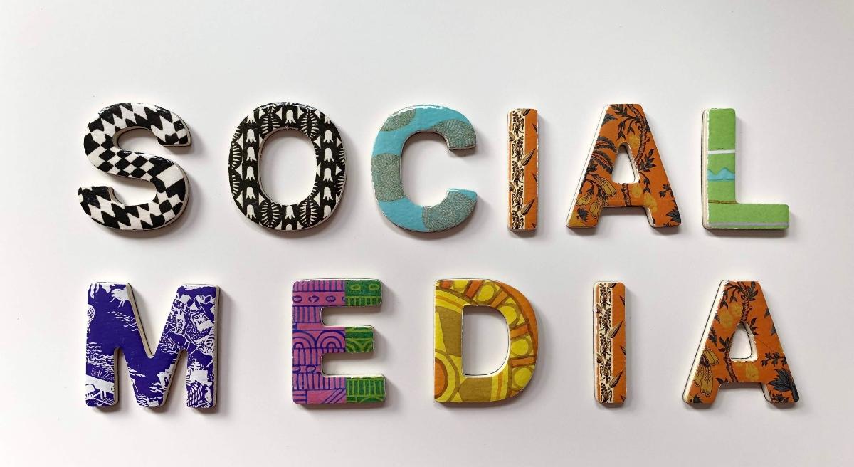 "Social Media" in various block letters on a wall