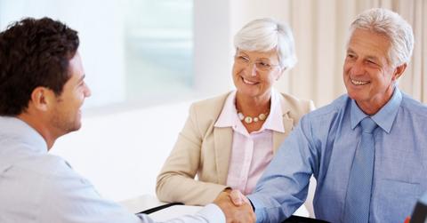 Elderly couple talking to a financial adviser about passive income investments