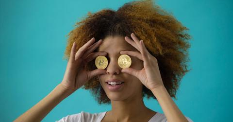 Women holding two coins on eyes