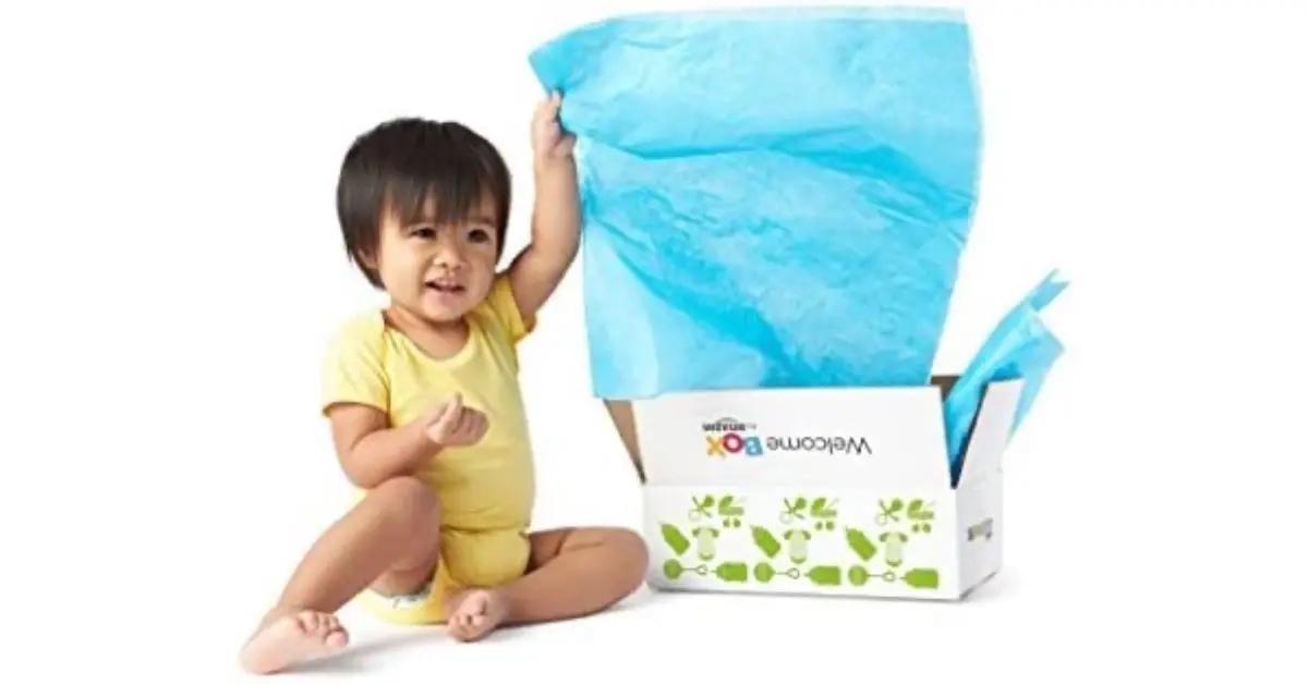 A baby in yellow pulls blue tissue paper out of Amazon's expecting mom gift box.