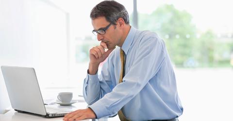 A man looking at tax information on a laptop