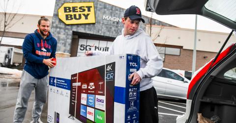 Men loading a Black Friday TV in a car.