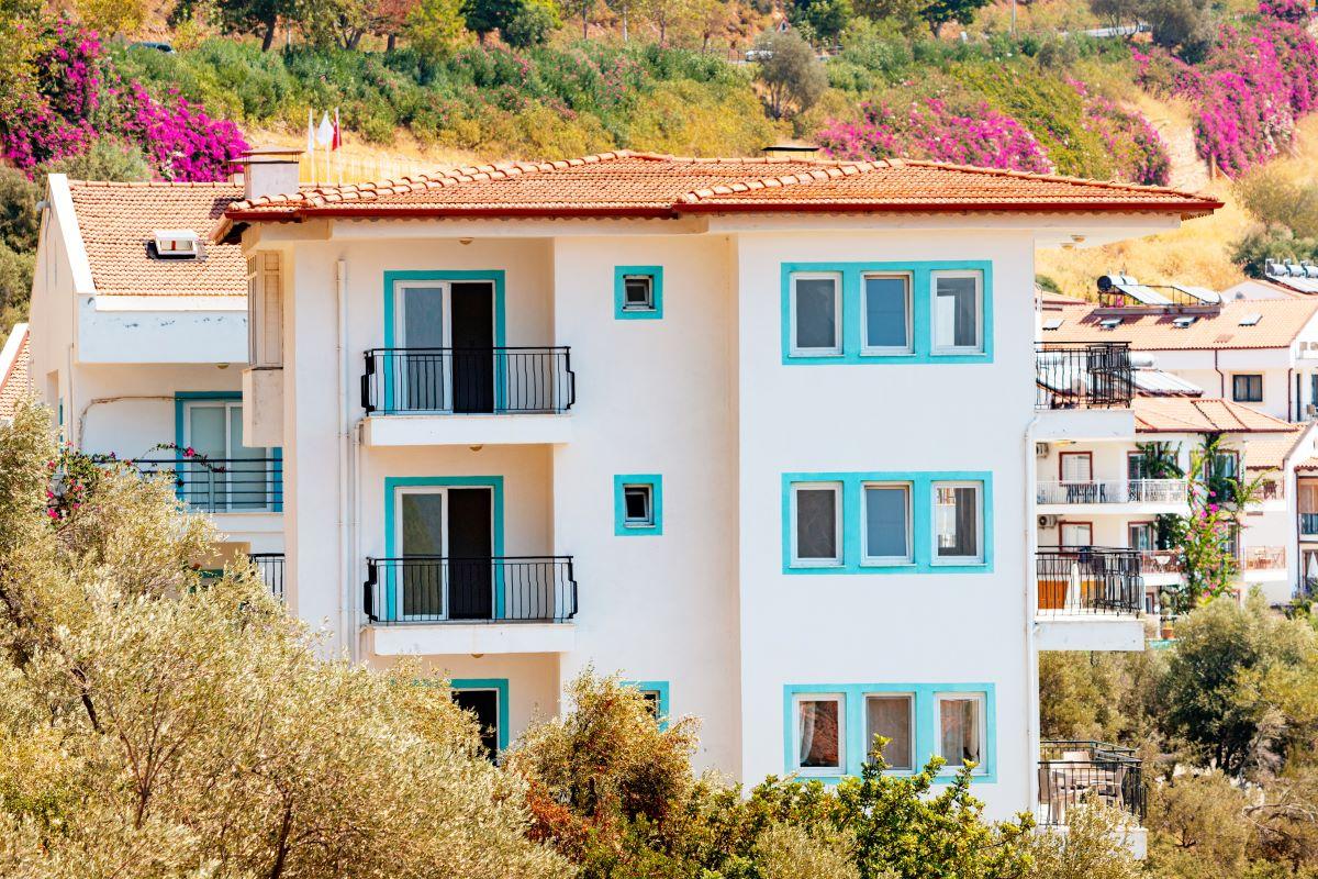 Houses and villas with red roofs in a resort town on mountain steep slope at the Mediterranean Sea. 