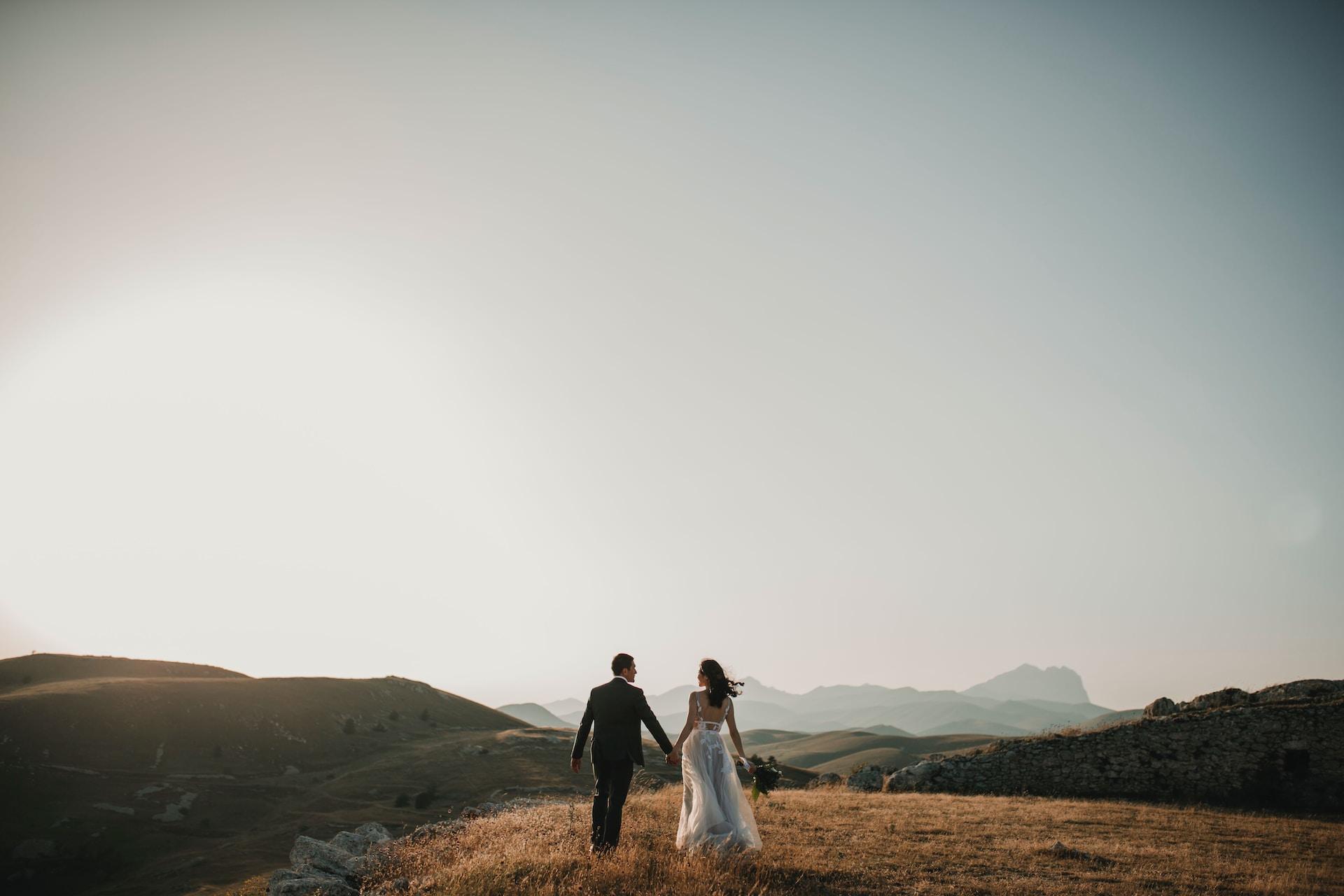 A newly wedded couple outside on a hill