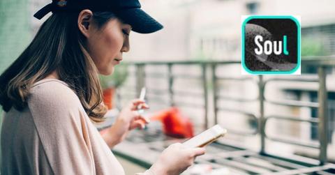 Woman looking at a smartphone and Soulgate logo