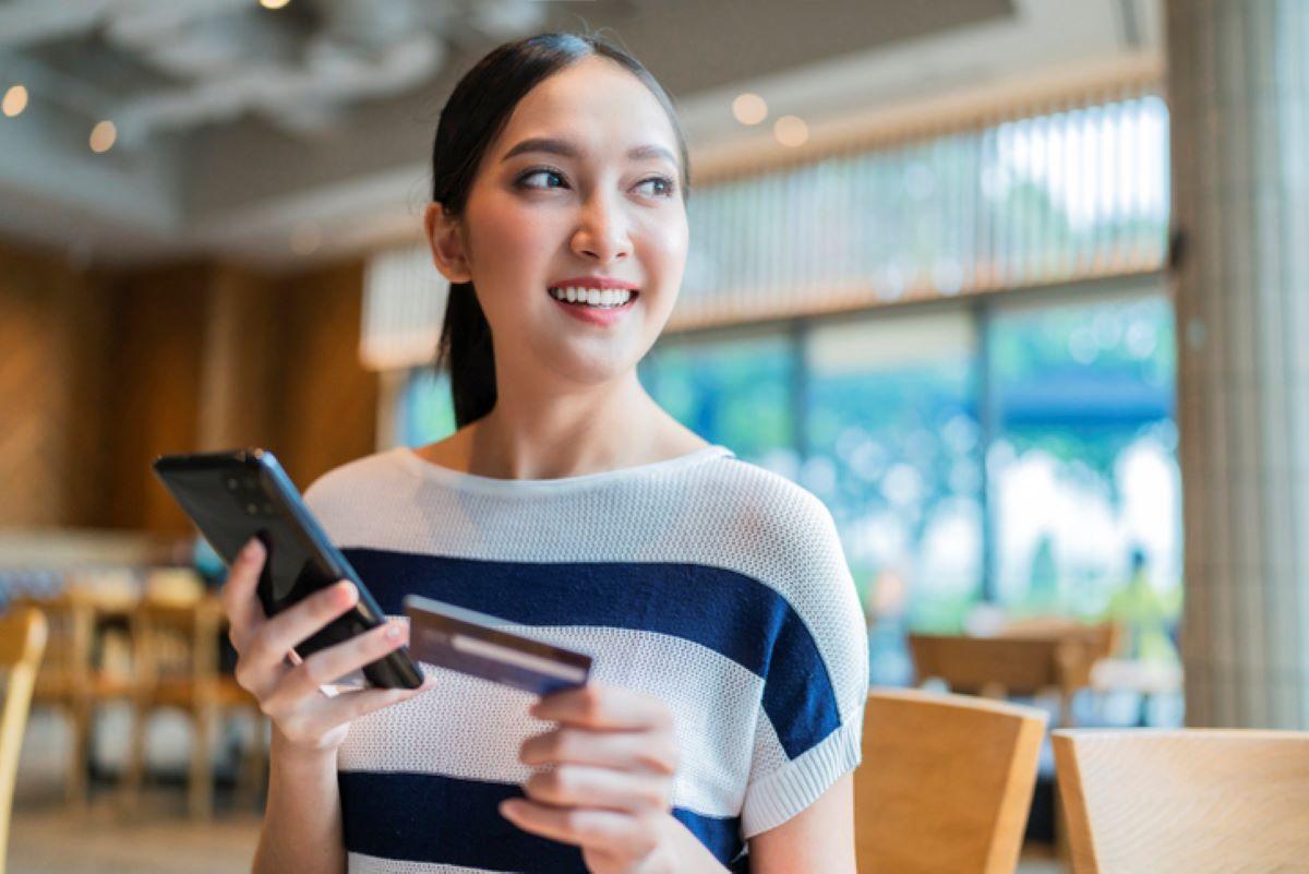 A happy woman shopping online with her credit card