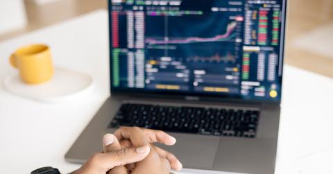 A man looking at stocks on a laptop