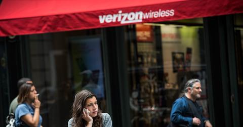 Woman uses her phone by Verizon shop