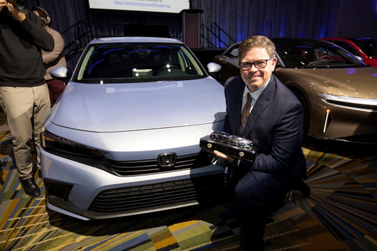 man posing in front of a honda civic