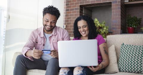 A smiling couple using a Chase credit card to make an online purchase