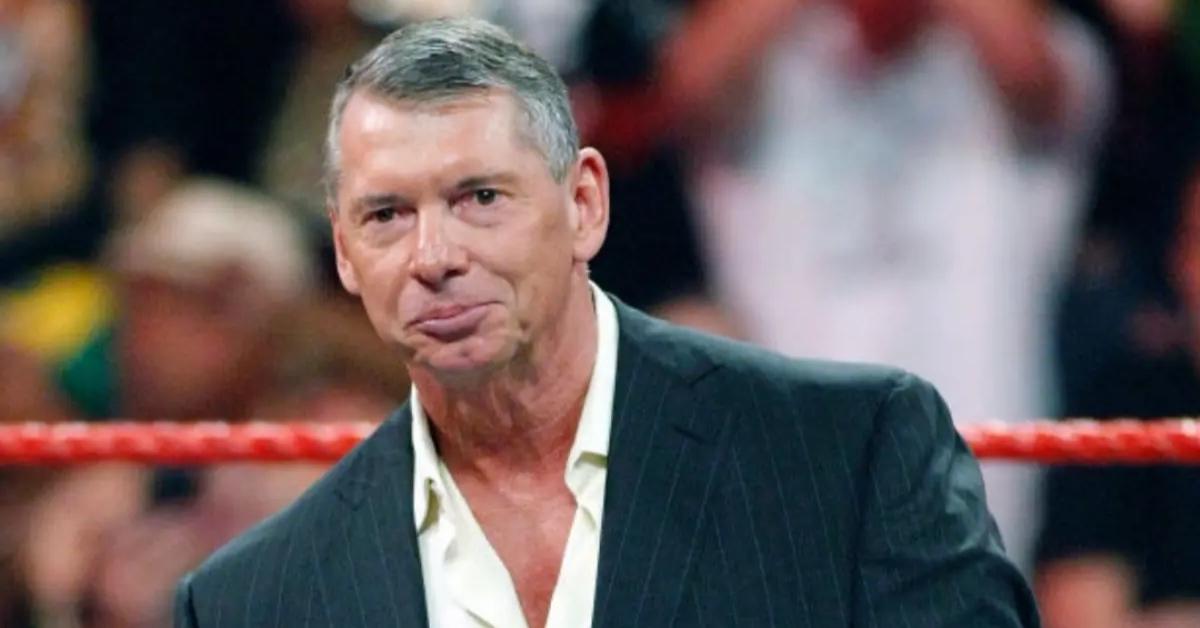 Vince McMahon in a suit standing in a wrestling ring in 2009.