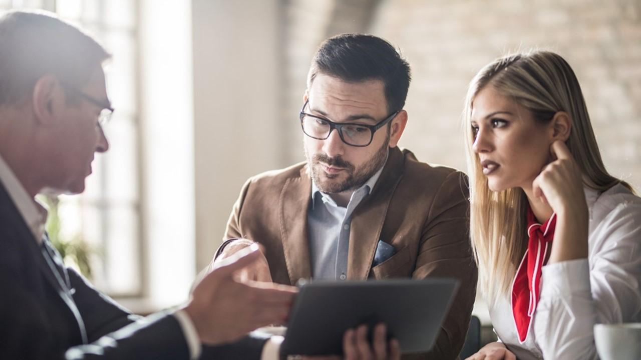 People discussing crypto data on a tablet