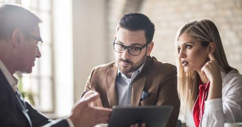 People discussing crypto data on a tablet