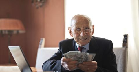 A senior person holding money in hands