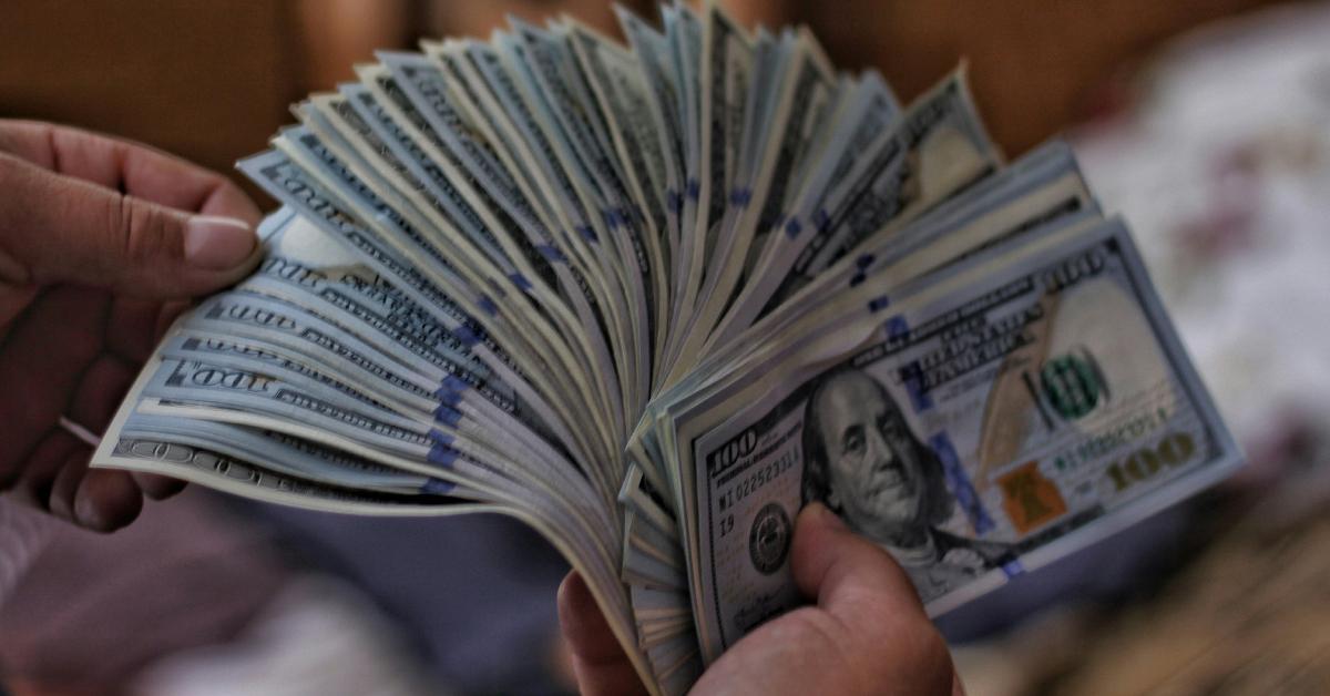 A person holding a ton of cash.