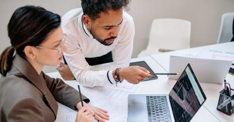 Two people looking at data on a laptop